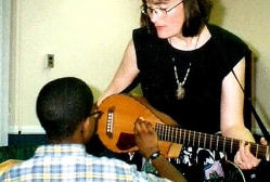 Margo Hennebach demonstrates her instrument to Dwayne in a shelter program